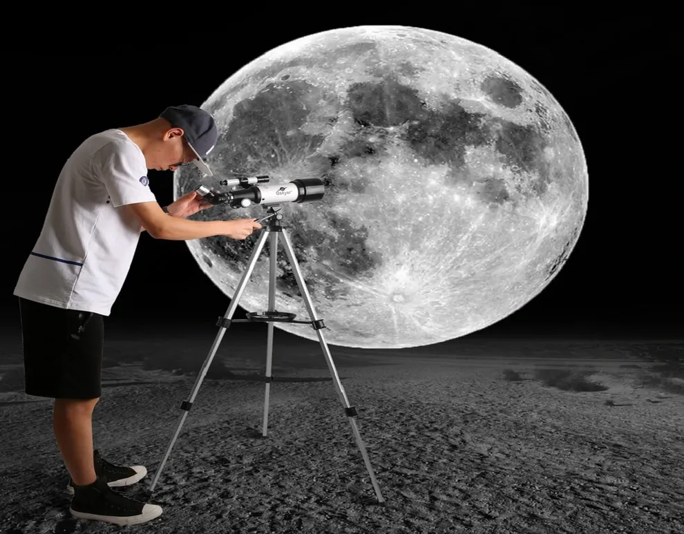 Hombre utilizando un telescopio Gskyer para observar la Luna en un entorno oscuro, con una vista detallada y cercana del satélite terrestre.